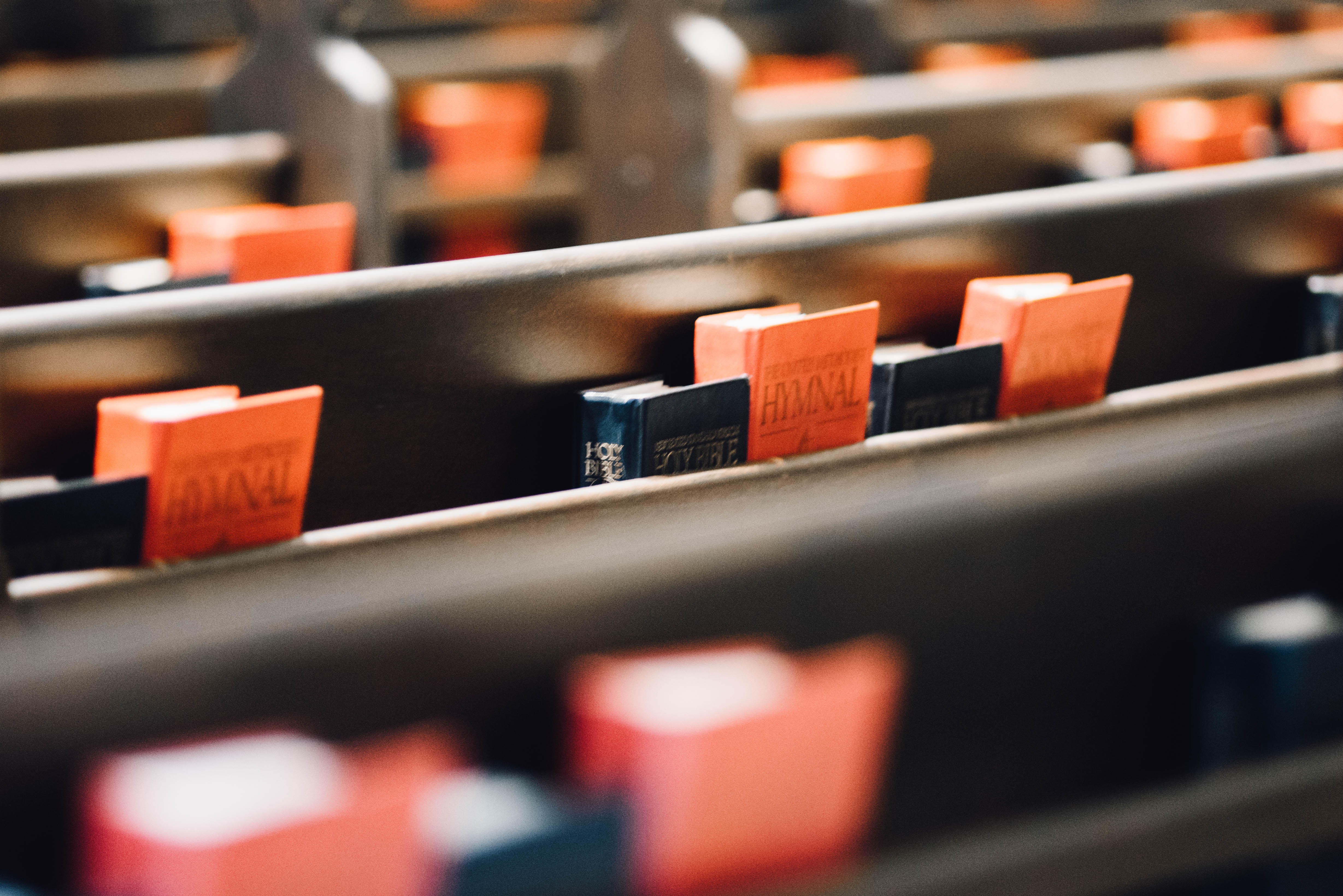 Hymnals and Bibles in church pews.